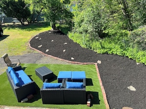 Un jardin avec un chemin sinueux, du mobilier d’extérieur et une bordure en briques.