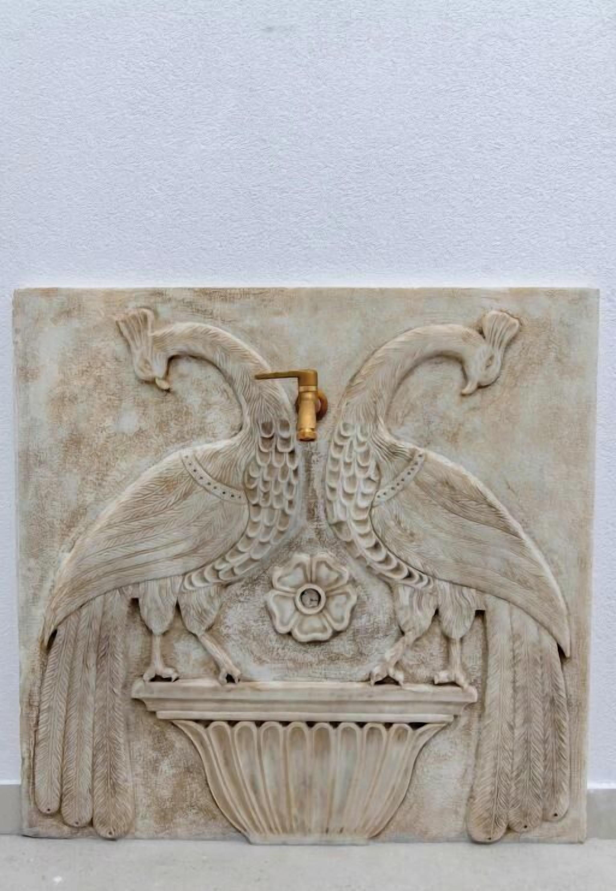 A detailed carved panel with two birds and a central floral motif.