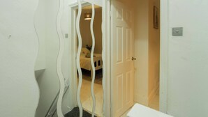 Un pasillo con una puerta blanca que da a un dormitorio.