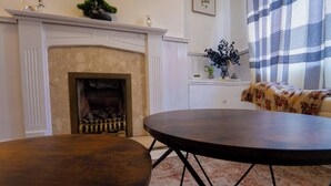 Una habitación con chimenea, una mesa redonda y un sofá.