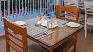 A dining area with a table set for two, overlooking a mountainous landscape. - The Fog Munnar Resorts And Spa (Devikolam)