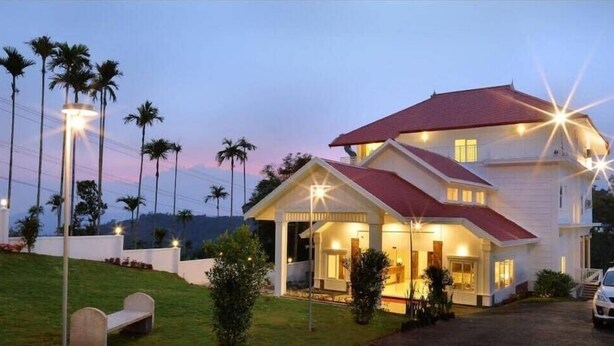 A two-story house with a red roof, a porch, and a driveway. - The Fog Munnar Resorts And Spa (Devikolam)