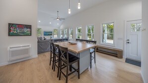 Une cuisine moderne avec un coin repas, de grandes fenêtres et un ventilateur de plafond.