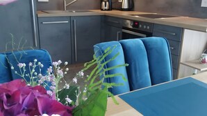 A modern kitchen with grey cabinets, a stainless steel sink, and a coffee maker. - Enjoy Sea Views & Tranquility – Exclusive Penthouse Apartment in Lauterbach Harbor (Putbus)