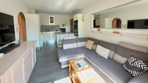 Een moderne woonkamer met een bank, salontafel en een televisie.