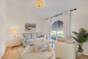 Ein modernes Wohnzimmer mit Sofa, Couchtisch und einer Topfpflanze.