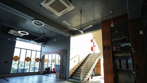 A modern interior with a staircase, elevator, and large windows with circular decorations. - HOTEL HIGHWAY QUEEN (Dudu)