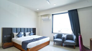 A modern hotel room with a large bed, two armchairs, a ceiling fan, and a window with curtains. - HOTEL HIGHWAY QUEEN (Dudu)