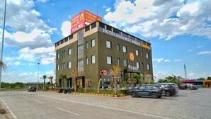 A multi-story hotel with a prominent sign for 'HOTEL HIGHWAY QUEEN ROOMS.' - HOTEL HIGHWAY QUEEN (Dudu)
