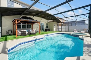 A swimming pool with a covered patio area, a pergola, and outdoor furniture. - 6BR Oasis w/ Private Pool, Game Room & Lanai (Davenport)