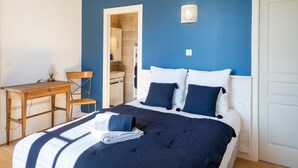 Een slaapkamer met een bed, een bureau en een stoel.