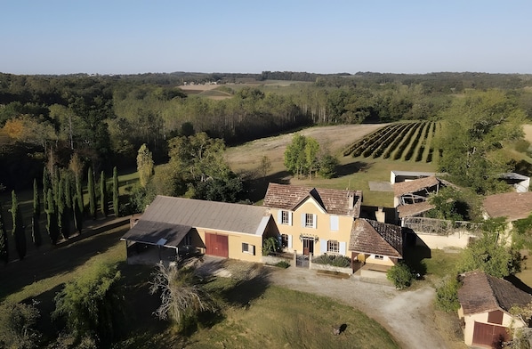 Une propriété rurale comprenant une grande maison, une grange et un vignoble.