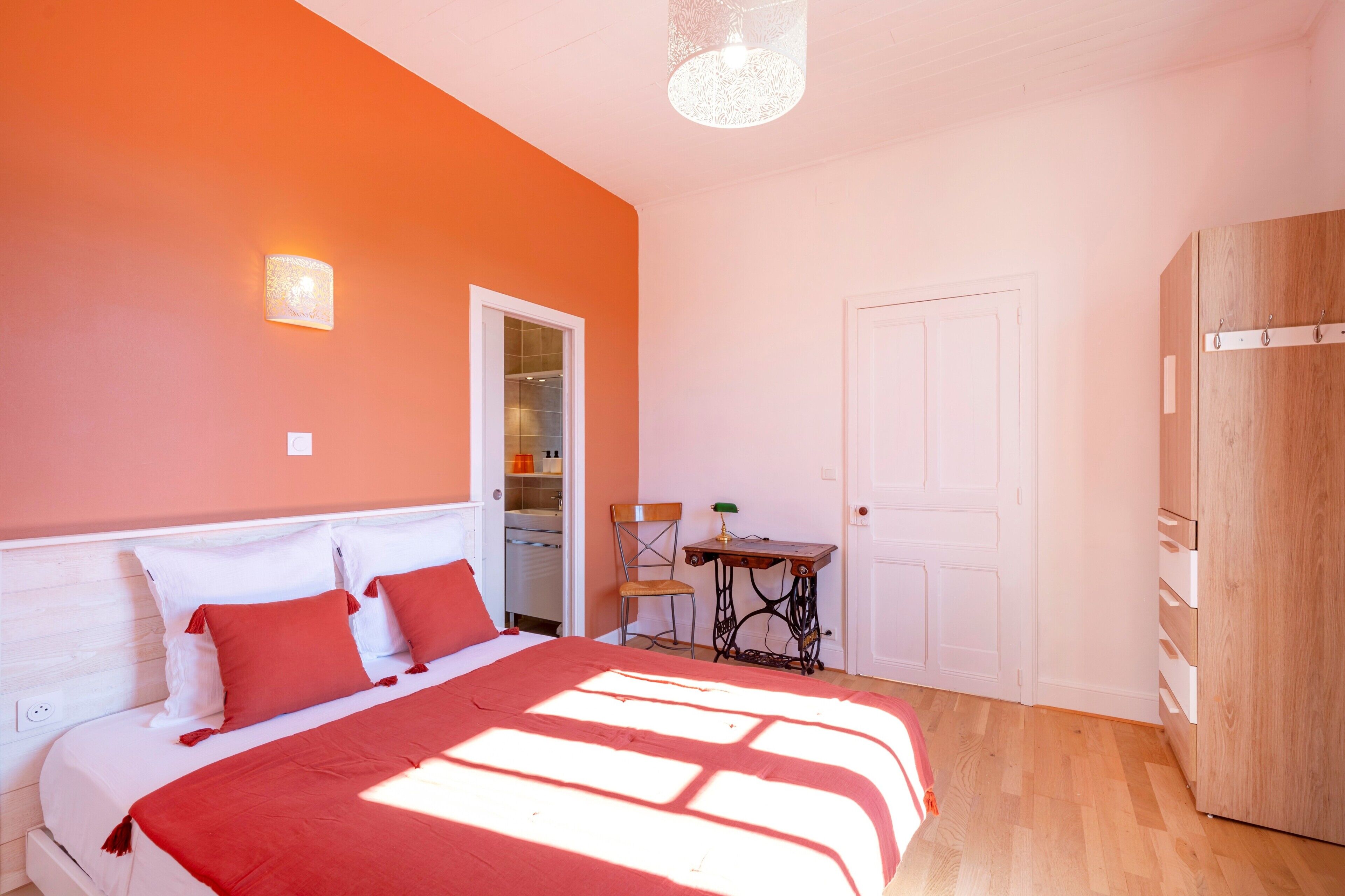 Une chambre à coucher avec un lit, une chaise, une table et une armoire.