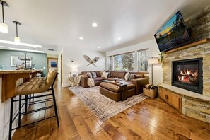 A modern living room with a fireplace, a sectional sofa, and a bar area. - The “Pine Tree Cabin”. Hot Tub, 4Br, 2 Ba, A/C, Near beaches, casinos, skiing (Stateline)