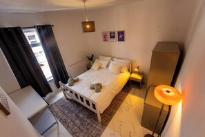 A bedroom with a bed, bedside table, lamp, and a view of the outside. - Room-comfy One-bdr in a Manchester House (Manchester)