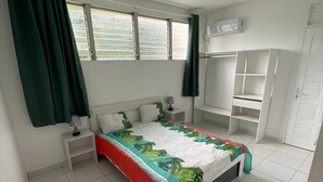 Une chambre à coucher comprenant un lit, des tables de chevet, une armoire et une fenêtre avec des rideaux.