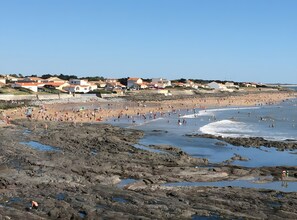 A coastal beach scene with rocky terrain and a residential area in the background. - Holiday Home for 6, 100 m from the Sea, Sea View, Shared Pool! (Bretignolles-sur-Mer)