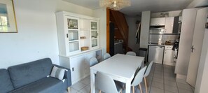 A compact living space with a dining area, kitchenette, and a grey sofa. - Holiday Home for 6, 100 m from the Sea, Sea View, Shared Pool! (Bretignolles-sur-Mer)