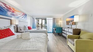 Ett hotellrum med en säng, två sängbord, ett skrivbord, en stol och ett stort fönster.