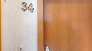 Una porta di legno con il numero 34 appeso al muro accanto.