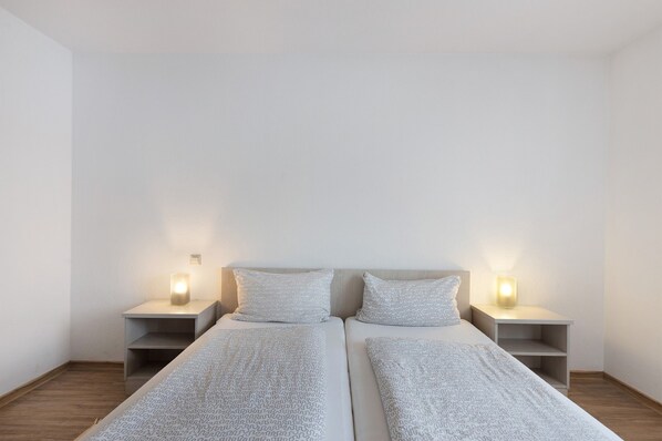 A twin room with two beds, nightstands, and bedside lamps.