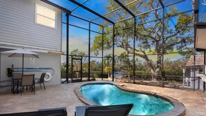 A swimming pool with a view of trees and a building. - Heron Lagoon Hideaway (Siesta Key)