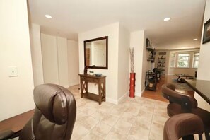 A spacious room with a dining area, a mirror, and a small table with a vase. - Everett - Free parking - Wi-Fi - Spacious - W/D (Everett)