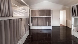A modern room with a bunk bed, a large window with curtains, and a dark wooden floor. - A Bica Hostel (Ponta Delgada)