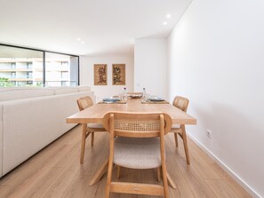 Un espace repas moderne avec une table en bois, quatre chaises et un canapé.