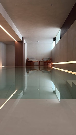 A spacious room with a reflective floor, two wicker chairs, and a minimalist design. - Dimora Vadalusa (Agrigento)