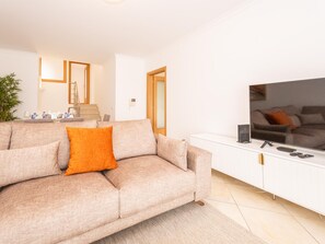 A living room with a sofa, a TV, and a white cabinet. - Escape Exclusivo em Tavira (Tavira)