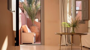 Un interno moderno con una scala che conduce a un balcone, un tavolino con una pianta e vista sull'esterno.