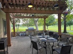 An outdoor patio with a grill, seating, and a view of a golf course. - Golf, Pickleball and Tennis in a spacious 4 bedroom, 4 Bath home (Kerrville)