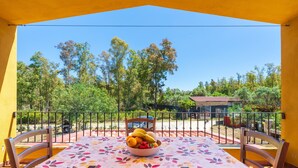 A balcony with a table, chairs, and a bowl of fruit. - Apartment 'Casa Delle Mimose Con Terrazza' with Private Terrace, Wi-Fi and Air Conditioning (Cardedu)