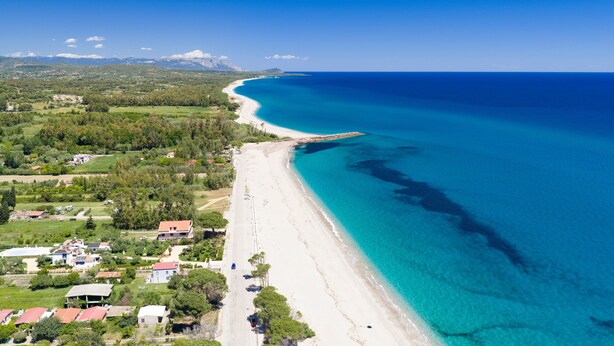 An aerial view of a coastal area with a beach, houses, and greenery. - Apartment 'Casa Delle Mimose Con Terrazza' with Private Terrace, Wi-Fi and Air Conditioning (Cardedu)
