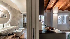 Une salle de bain moderne avec un grand lavabo, un bidet et un meuble-lavabo en bois.