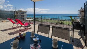 A balcony with a table set for two, red chairs, and a view of the ocean. - [Sea View Penthouse] Free Park • A/C • Hiper Wifi (Savona)