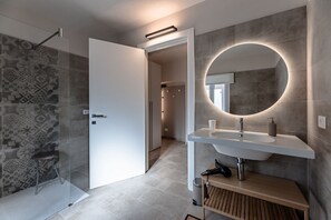 A modern bathroom with a shower, a sink with a mirror, and patterned tiles. - [Alta Via 1] Free Parking • Sea 20 min • A/C (Altare)
