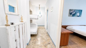 A narrow hallway with a bunk bed, a small table, and a painting on the wall. - Casa dei Cigni Finale Ligure (Finale Ligure)