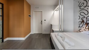 Una habitación de hotel con una cama, un baño con espejo y una puerta que da a otra habitación.