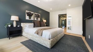 Una camera da letto moderna con un letto, comodini e opere d'arte alle pareti.