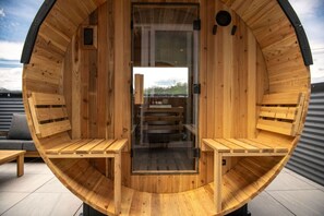 A wooden sauna with benches and a glass door, set on a tiled roof. - Rooftop Sauna + Hot Tub | Spa Room | Cabana! (Pittsburgh)
