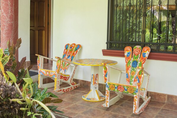 A patio with a table and two chairs, a window with a metal grill, and a door. - Private Suite 102 Walking Distance to the Beach (Bahía Ballena)