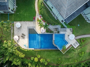 An aerial view of a resort with a large swimming pool, lounge chairs, and palm trees. - Condo With Stunning Beach and Wildlife Views (Bahía Ballena)