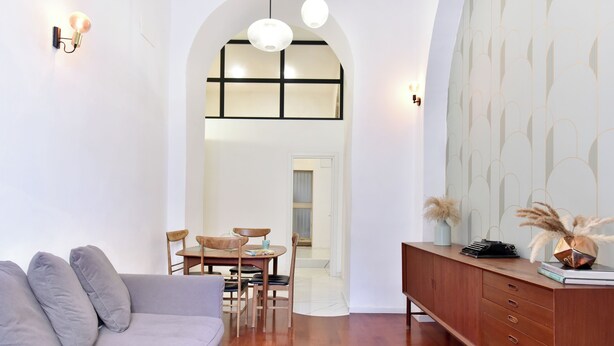 Un salon moderne comprenant un canapé, une table à manger, des chaises et un meuble en bois.