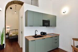 A compact kitchen with a sink, a coffee maker, and a built-in oven. - 4BNB - Loft Colosseum 1 (Rome)