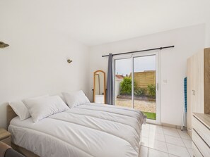 Un dormitorio con cama, armario y puerta corrediza de vidrio que da a un patio.