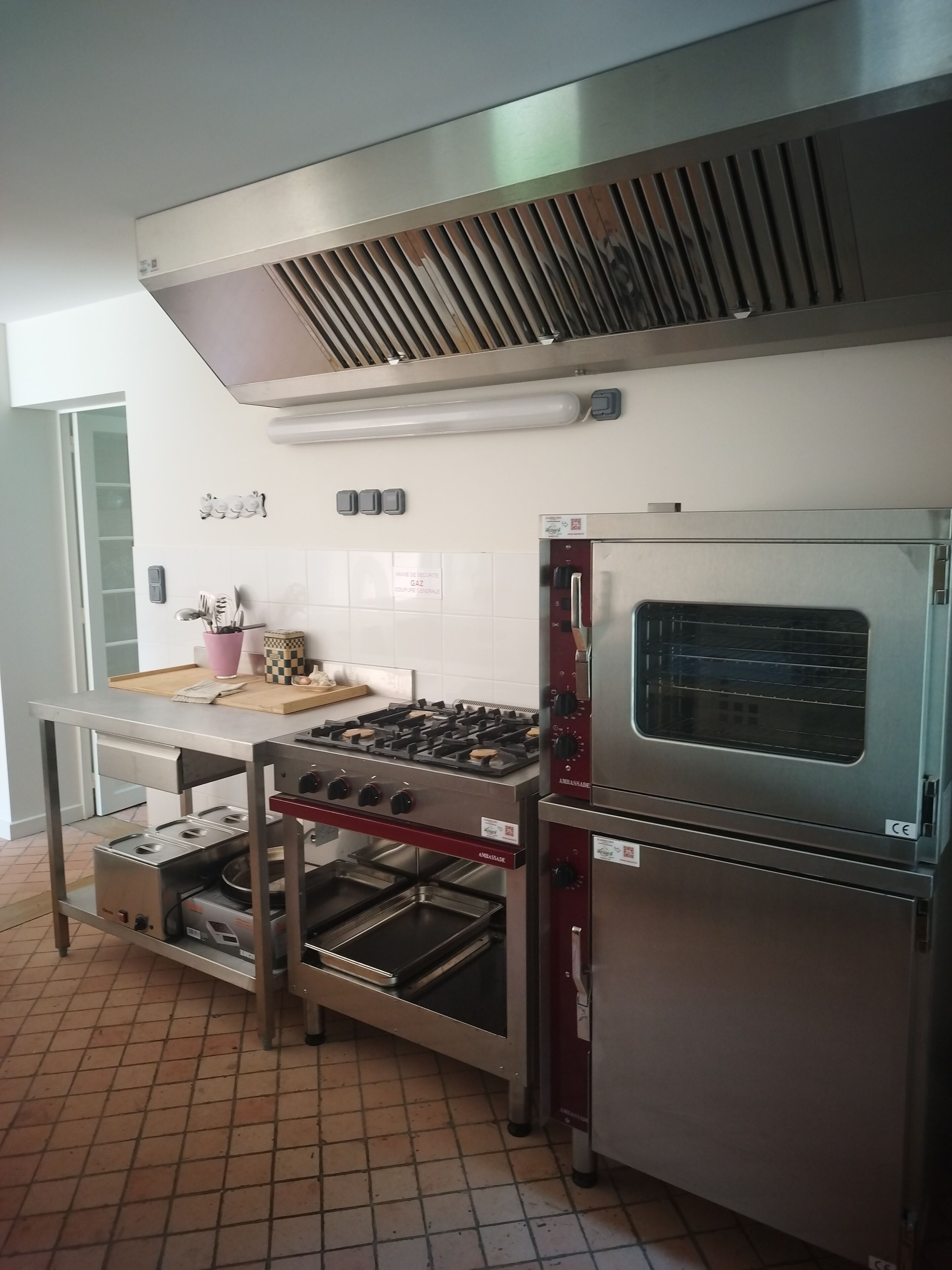 A kitchen with stainless steel appliances, a gas stove, a built-in oven, and a ventilation hood.