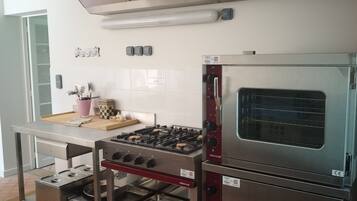 A kitchen with stainless steel appliances, a gas stove, a built-in oven, and a ventilation hood.