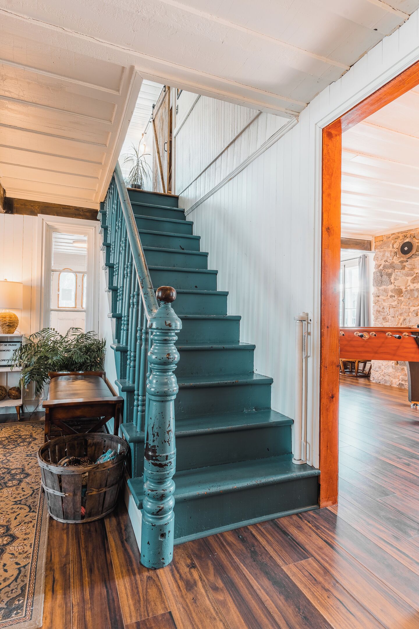 A staircase with a wooden handrail and a blue painted railing.
